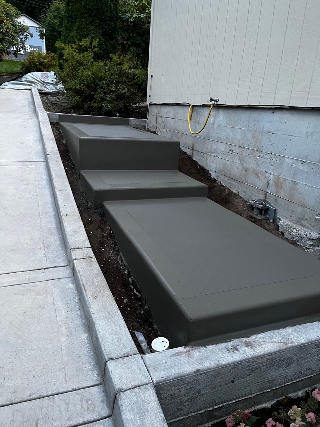 New concrete steps and landings running along the side of a house